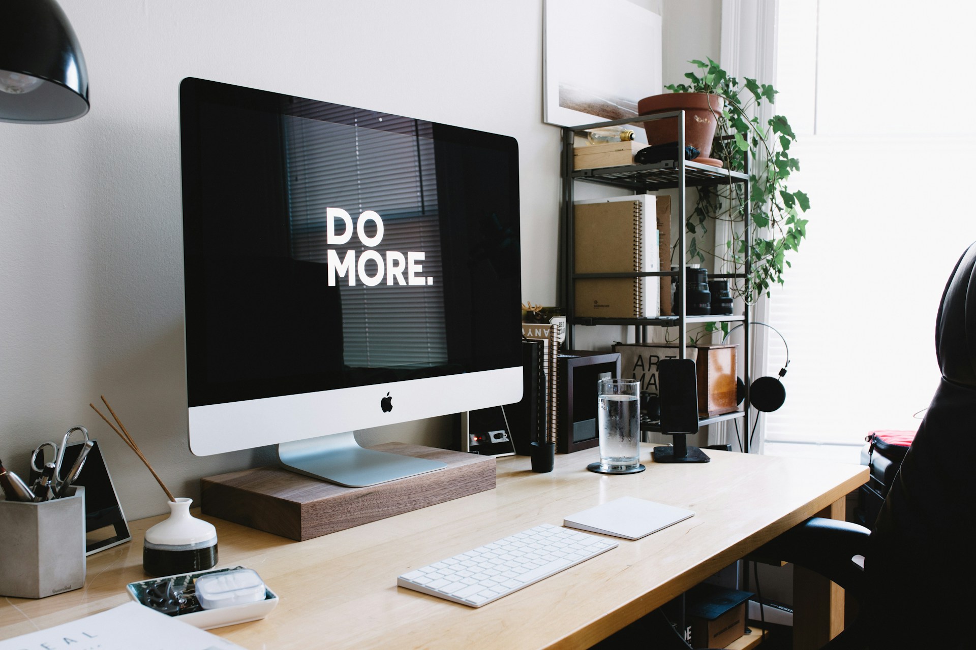 Een foto van een bureau met daarop een scherm waarop staat 'Do more'. Het representeert de tips om productief te werken.